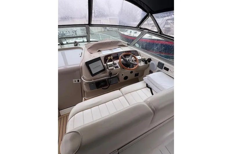 Slide: The Image of 1998 Sea Ray Sundancer 330 helm with Garmin navigation, featuring a wooden steering wheel and cushioned seating. - 5