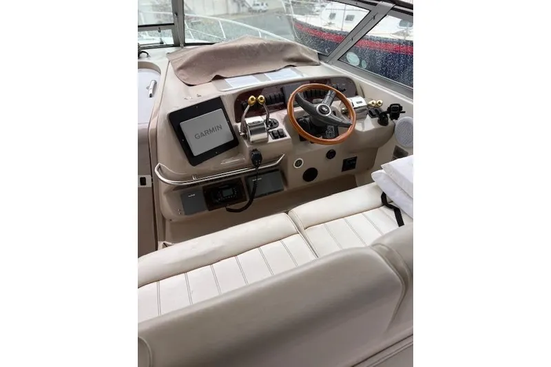 Slide: The Image of 1998 Sea Ray Sundancer 330 helm with Garmin navigation, wooden steering wheel, and beige seating. - 6