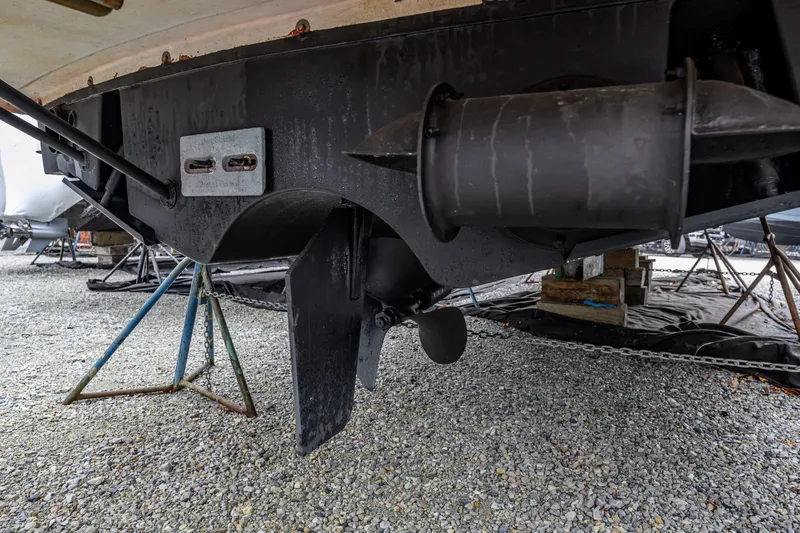 Slide: The Image of 2005 MJM 34z Downeast boat underside with propeller and rudder on gravel. - 13