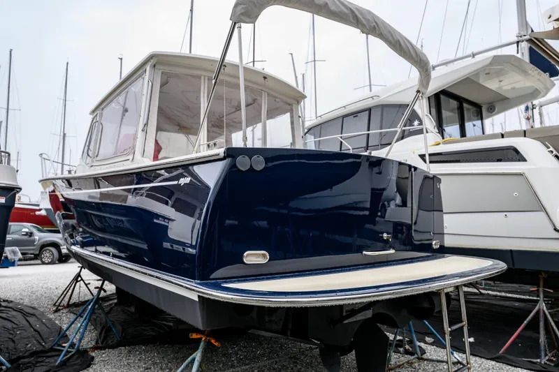 Slide: The Image of 2005 MJM 34z Downeast boat in a marina, blue hull, on stands. - 14