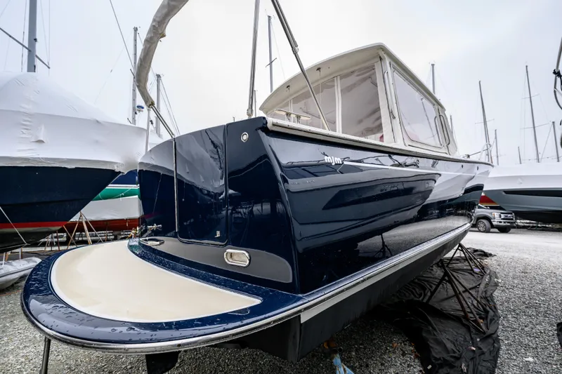 Slide: The Image of 2005 MJM 34z Downeast boat in storage, showcasing sleek design and glossy finish. - 15