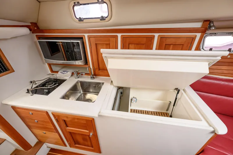 Slide: The Image of 2005 MJM 34z Downeast yacht kitchen with sink, stove, microwave, and storage cabinets. - 17
