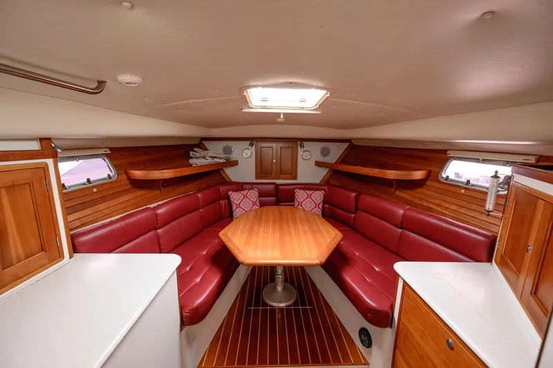 Slide: The Image of 2005 MJM 34z Downeast yacht interior with red leather seating and wooden table. - 21