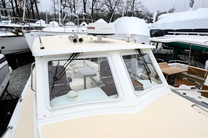 Slide: The Image of 2005 MJM 34z Downeast boat in marina, surrounded by other vessels and covered structures. - 27
