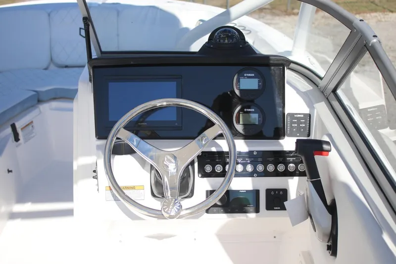 Slide: The Image of 2026 Sea Fox 228 Traveler boat dashboard with steering wheel and navigation controls. - 7