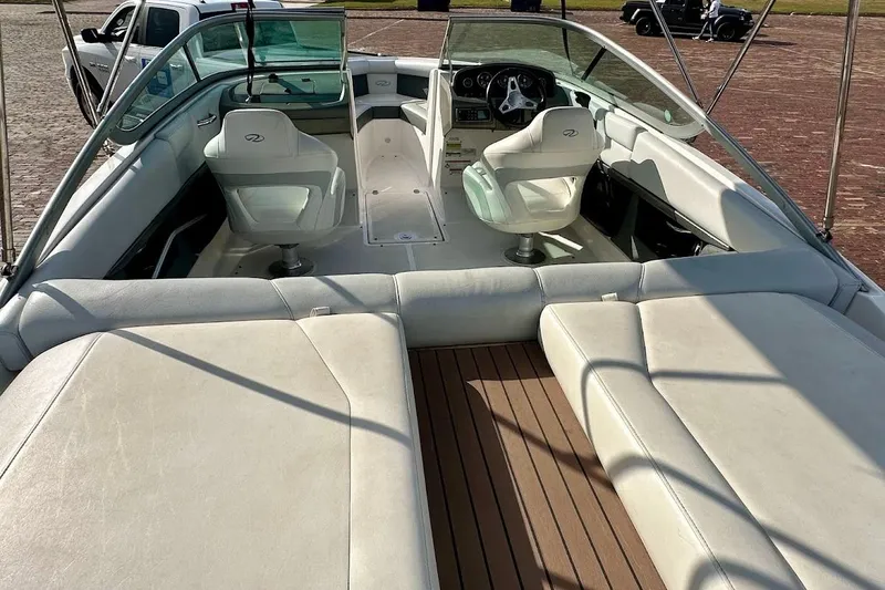 Slide: The Image of 2012 Regal 2100 Bowrider interior with white seating and wooden flooring. - 12