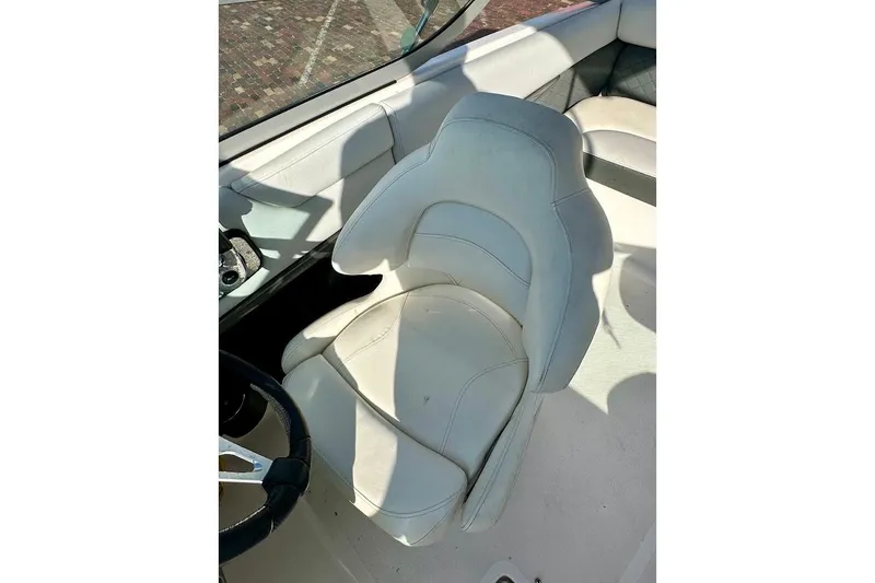 Slide: The Image of 2012 Regal 2100 Bowrider boat interior with white captain's seat and steering wheel. - 15