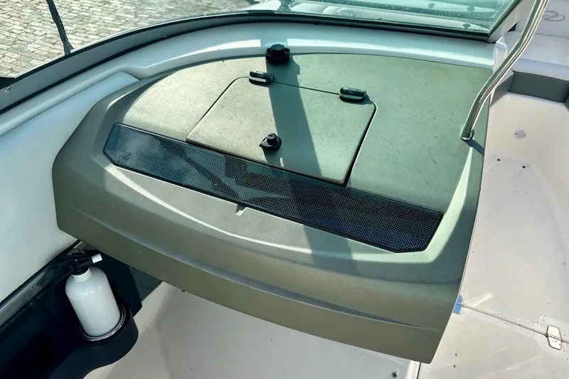 Slide: The Image of 2012 Regal 2100 Bowrider dashboard with storage compartment and windshield. - 17