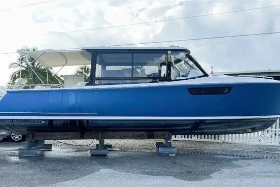 Slide: The Image of 2022 MJM 3 boat in blue, displayed on stands, with a white canopy. - 8