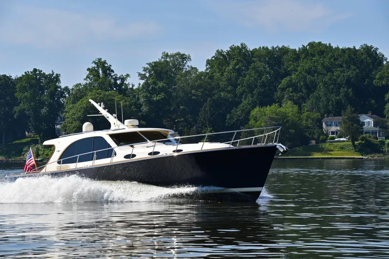 Slide: The Image of 2020 Palm Beach Motor Yachts PB52 cruising on a serene lake with lush greenery. - 54