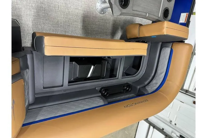 Slide: The Image of 2026 Bennington 22 SSB Swingback interior with tan seating and storage compartment. - 10