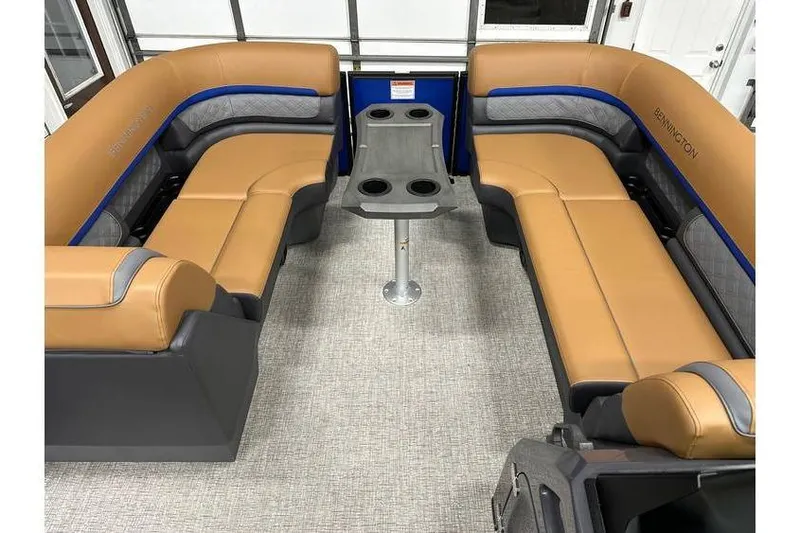 Slide: The Image of 2026 Bennington 22 SSB Swingback interior with tan seating and central table. - 12