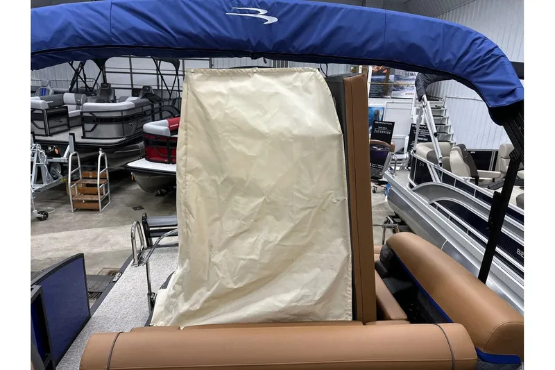 Slide: The Image of 2026 Bennington 22 SSB Swingback pontoon boat with blue canopy in showroom. - 29