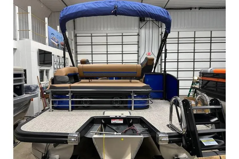 Slide: The Image of 2026 Bennington 22 SSB Swingback pontoon boat with blue canopy in showroom. - 3