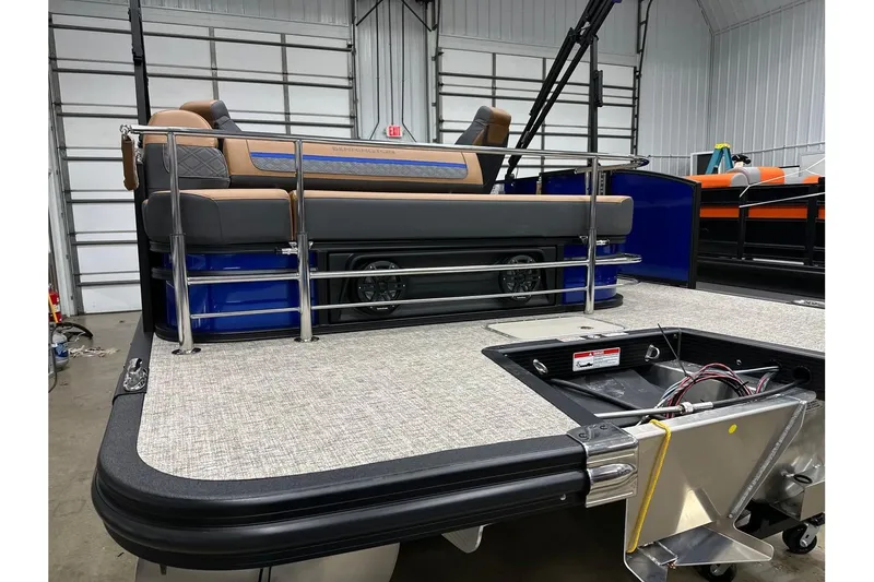 Slide: The Image of 2026 Bennington 22 SSB Swingback pontoon boat interior with seating and railing in a garage. - 32