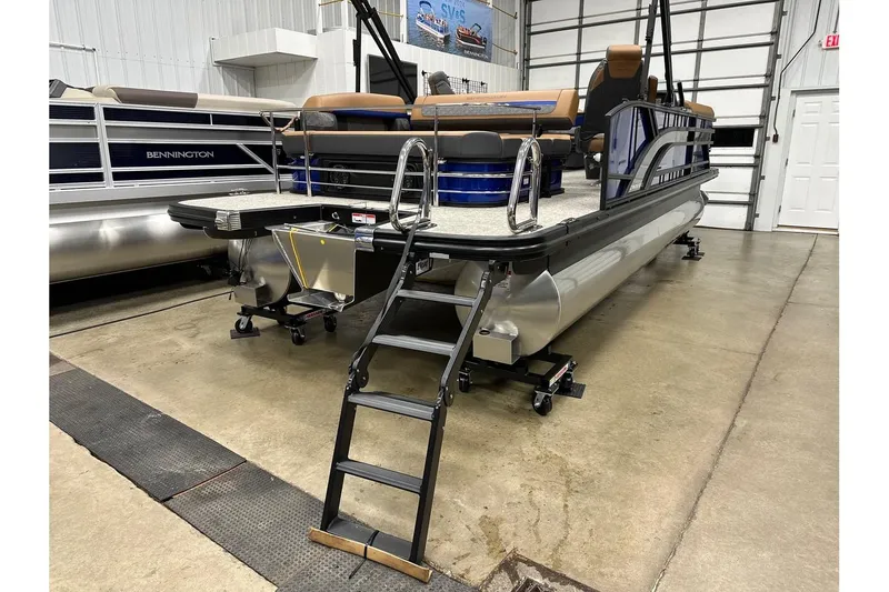 Slide: The Image of 2026 Bennington 22 SSB Swingback pontoon boat in showroom, featuring sleek design and ladder. - 34