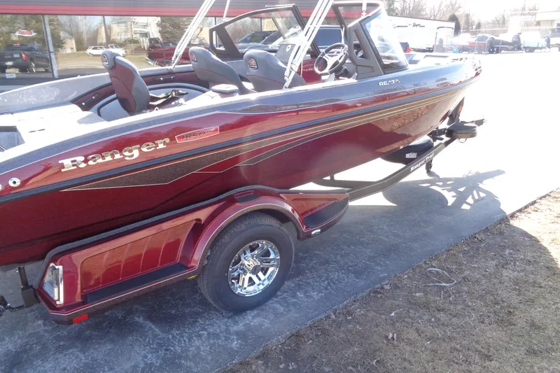 Slide: The Image of 2026 Ranger 1850MS Reata boat on trailer, maroon color, parked outdoors. - 12