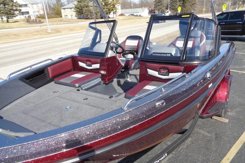 Slide: The Image of 2026 Ranger 1850MS Reata boat with red and gray interior, parked outdoors. - 8