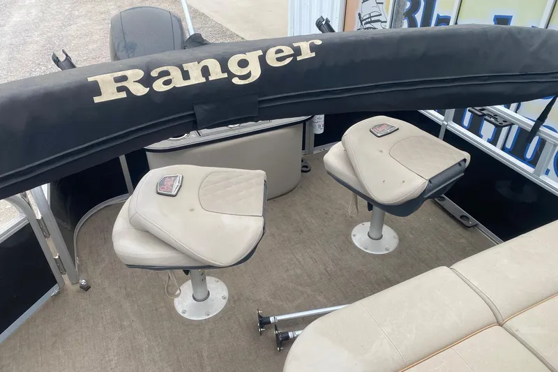 Slide: The Image of 2024 Ranger Reata 220F boat interior with seating and protective cover. - 10