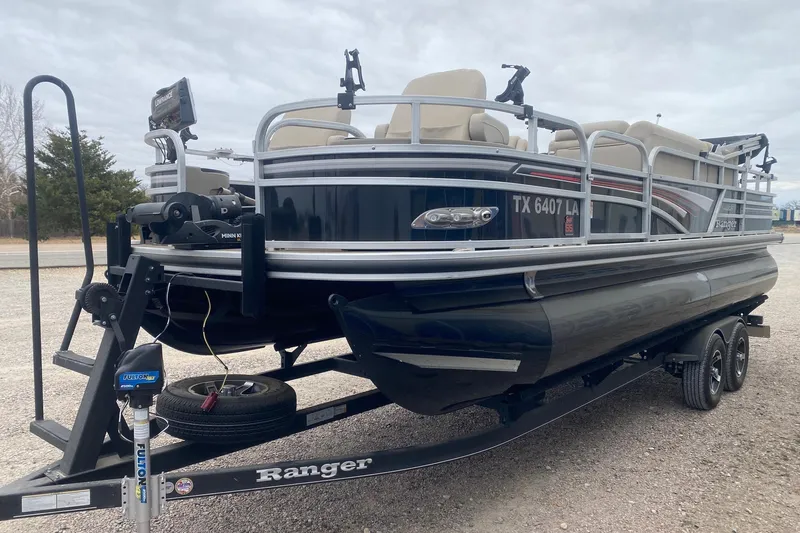 Slide: The Image of 2024 Ranger Reata 220F pontoon boat on trailer, parked outdoors. - 3
