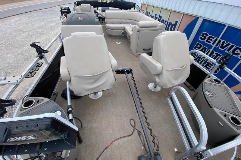 Slide: The Image of 2024 Ranger Reata 220F boat interior with beige seating and fishing equipment. - 7