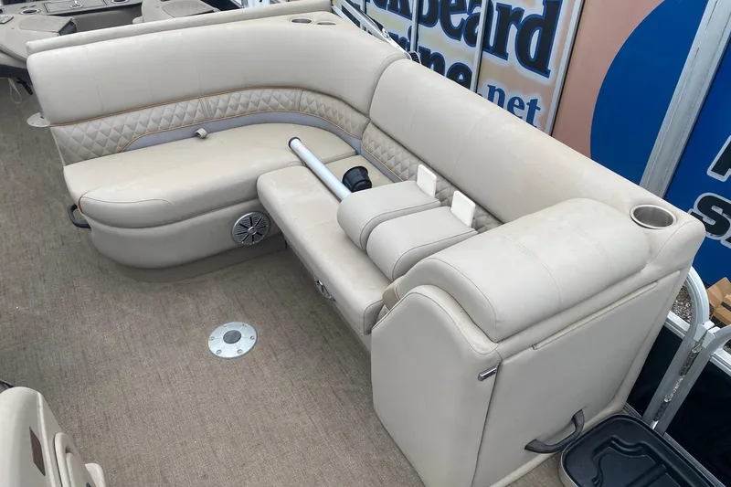 Slide: The Image of 2024 Ranger Reata 220F boat interior with beige seating and cup holders. - 8