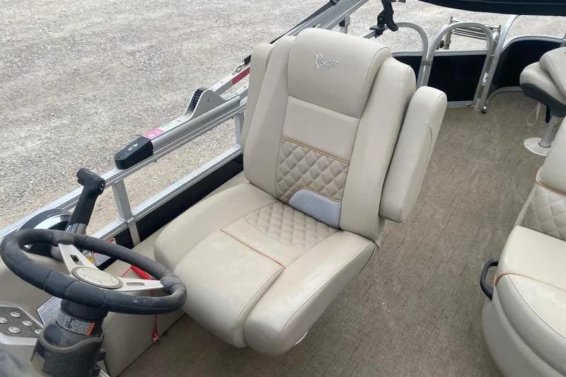 Slide: The Image of 2024 Ranger Reata 220F boat interior with plush seating and steering wheel. - 9