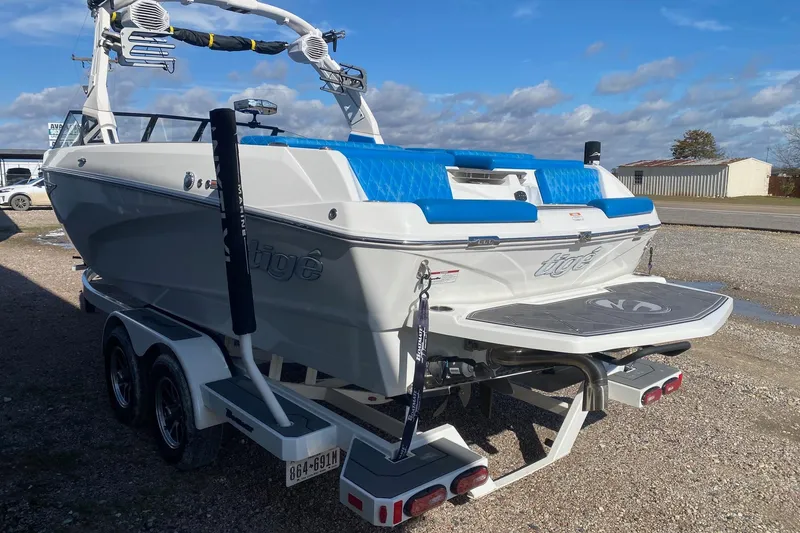 Slide: The Image of 2024 Tigé Z3 boat on trailer, featuring blue and white design under a clear sky. - 4