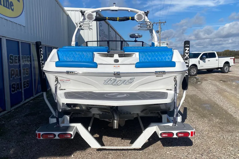Slide: The Image of 2024 Tigé Z3 boat with blue seating, parked near service center. - 5