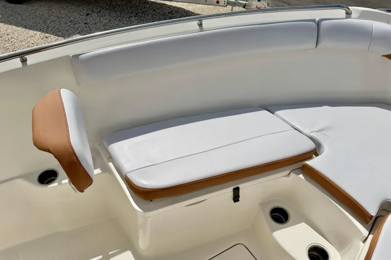 Slide: The Image of 2021 Sailfish 242 CC boat interior with white and brown cushioned seating. - 12