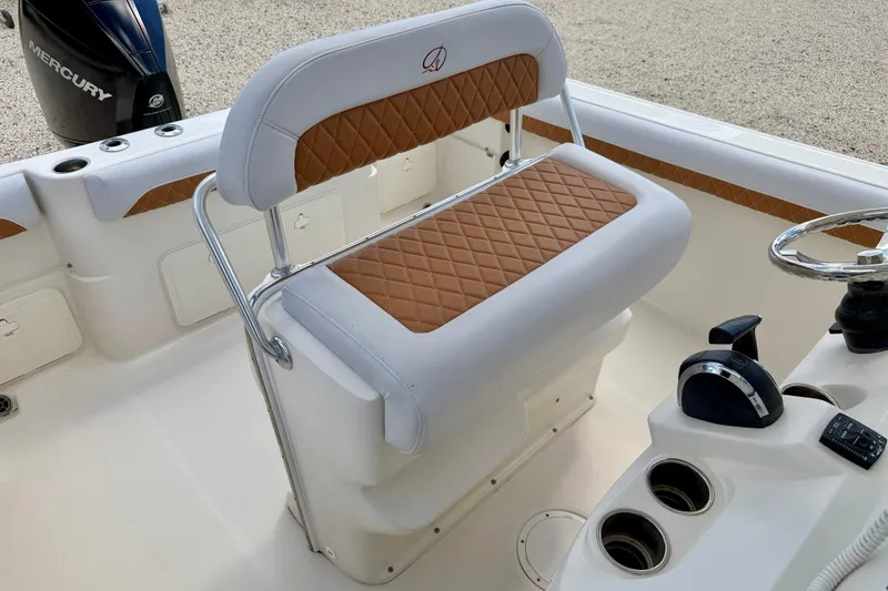 Slide: The Image of 2021 Sailfish 242 CC boat interior with cushioned seating and steering console. - 14