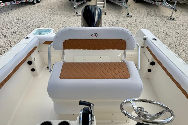 Slide: The Image of 2021 Sailfish 242 CC boat interior with tan diamond-stitched seating and steering wheel. - 16