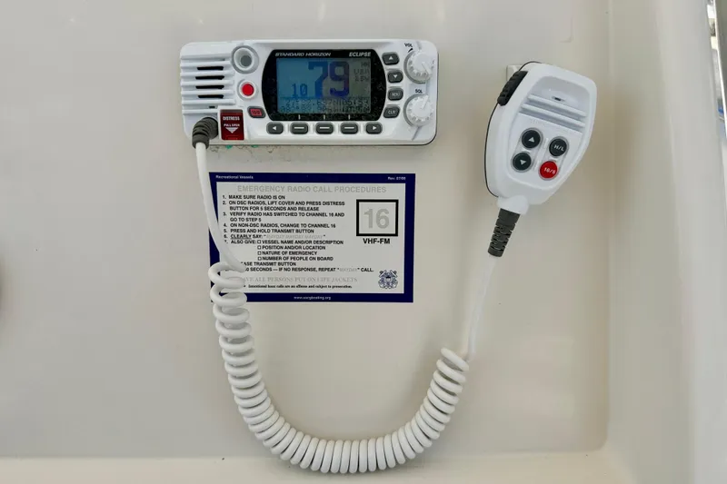 Slide: The Image of VHF radio system on 2021 Sailfish 242 CC boat with emergency call instructions. - 22