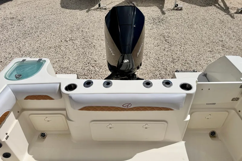 Slide: The Image of 2021 Sailfish 242 CC boat interior with motor, rod holders, and storage compartments. - 25