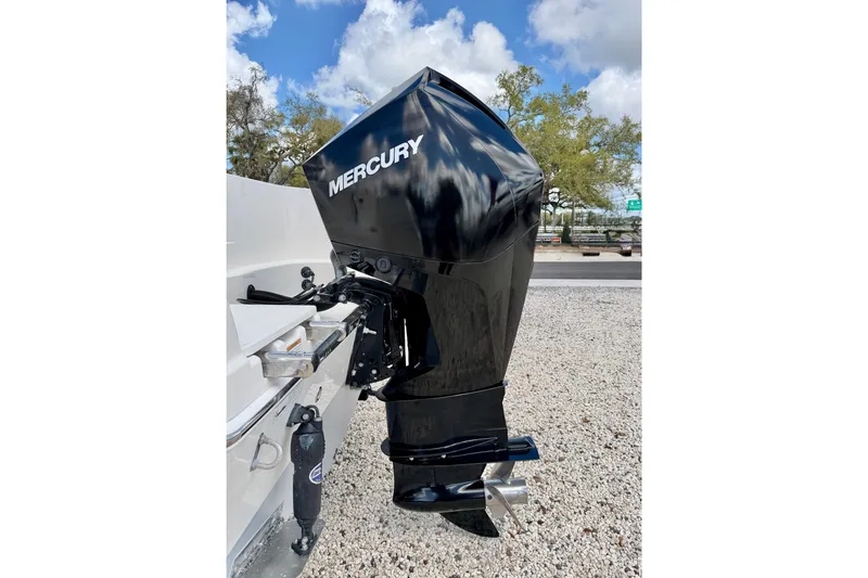 Slide: The Image of Mercury outboard motor on 2021 Sailfish 242 CC boat, parked on gravel. - 28