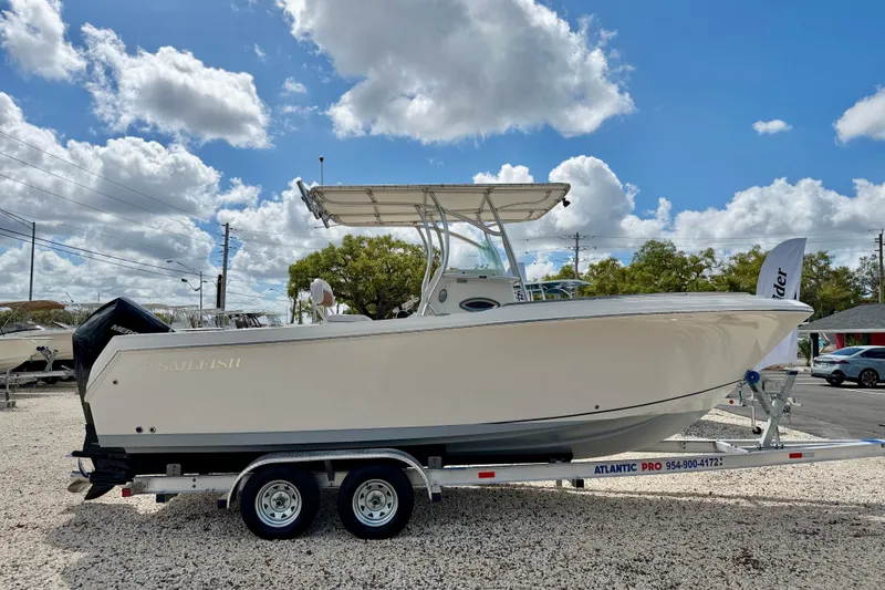 Slide: The Image of 2021 Sailfish 242 CC boat on trailer under blue sky with clouds. - 4