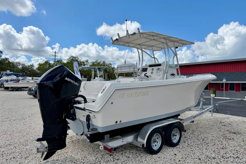Slide: The Image of 2021 Sailfish 242 CC boat on trailer with Mercury engine, parked outdoors. - 5