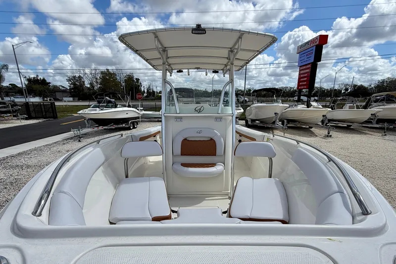 Slide: The Image of 2021 Sailfish 242 CC boat with white seating and T-top under cloudy sky. - 8