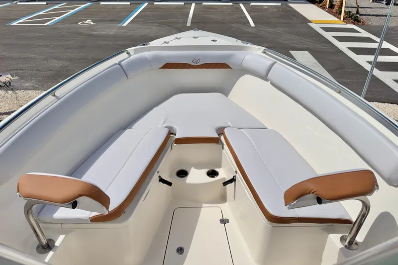 Slide: The Image of 2021 Sailfish 242 CC boat interior with cushioned seating and stainless steel handrails. - 9