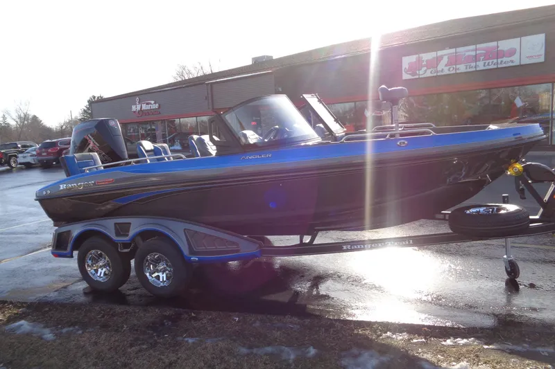 Slide: The Image of 2026 Ranger 1880MS Angler boat on trailer, parked outside a marine store. - 13
