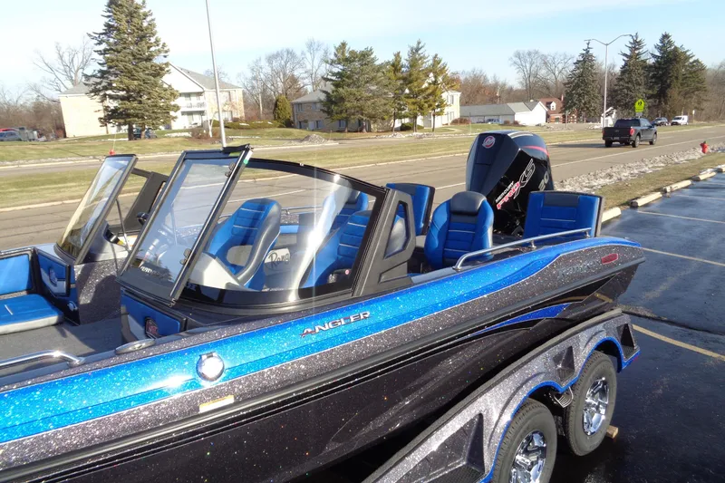 Slide: The Image of 2026 Ranger 1880MS Angler boat with blue seats and sleek design on a sunny day. - 15