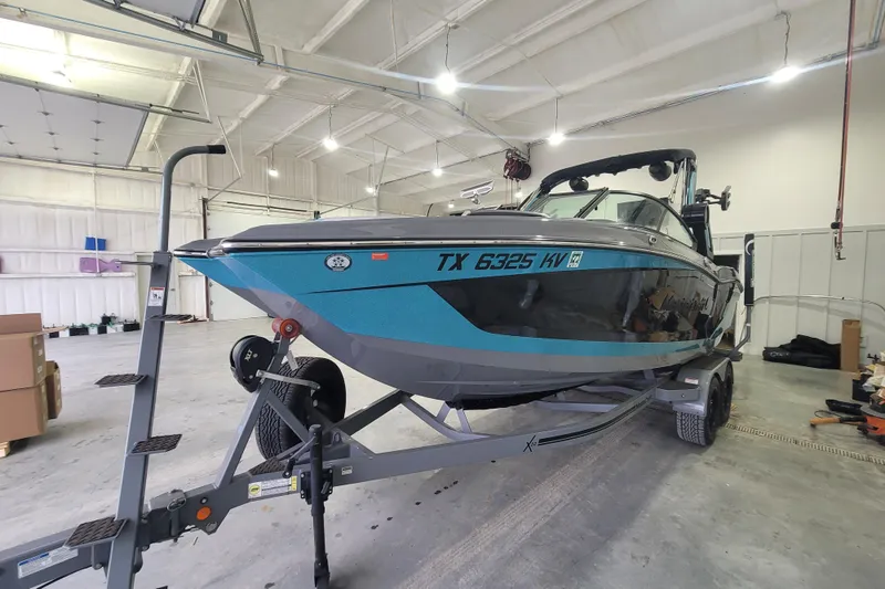 Slide: The Image of 2022 MasterCraft X22 boat on trailer in spacious indoor storage facility. - 10