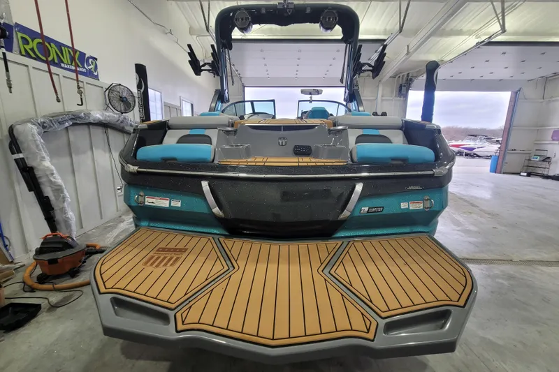 Slide: The Image of 2022 MasterCraft X22 boat in a garage, showcasing rear deck and seating. - 13