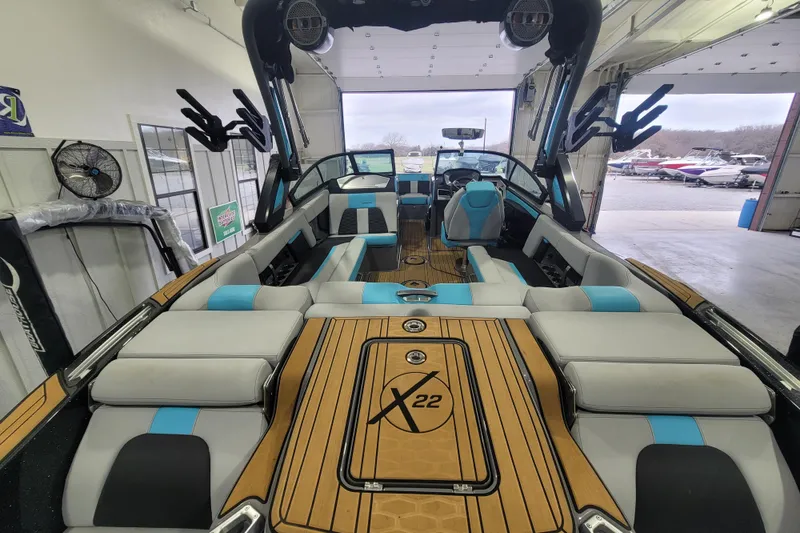 Slide: The Image of 2022 MasterCraft X22 boat interior with luxurious seating and modern design in a showroom. - 15