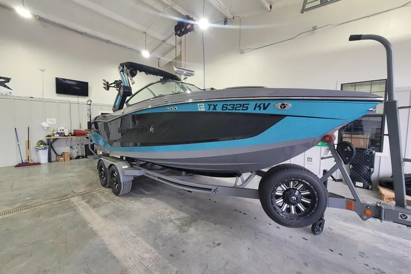 The Image of 2022 MasterCraft X22 boat on trailer in a garage setting. - 7