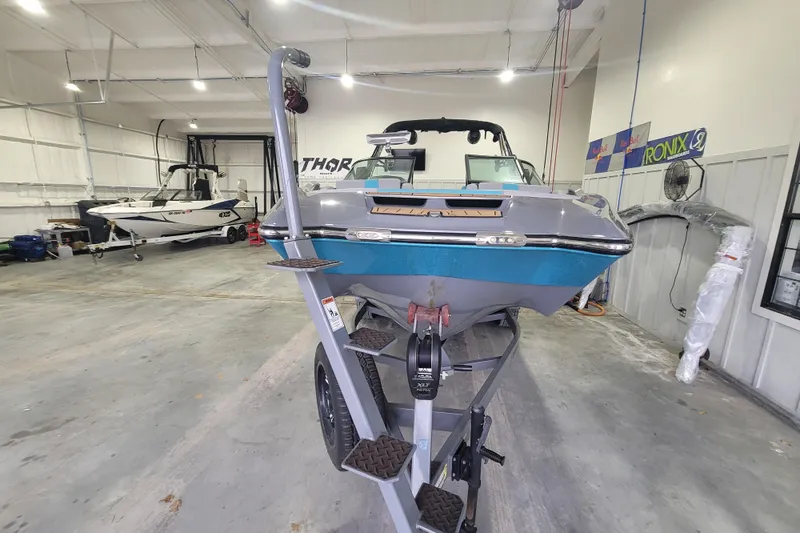 Slide: The Image of 2022 MasterCraft X22 boat in a showroom, front view on trailer. - 9