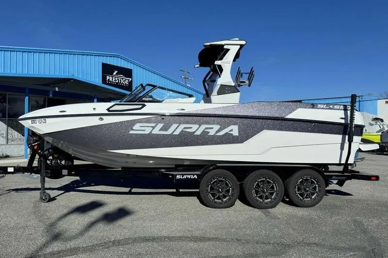 The Image of 2022 Supra SL boat on trailer outside Prestige Water Sports dealership. - 1