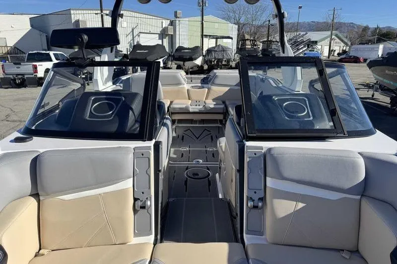 Slide: The Image of 2022 Supra SL boat interior with beige and gray seating, open windshield, and modern design. - 13