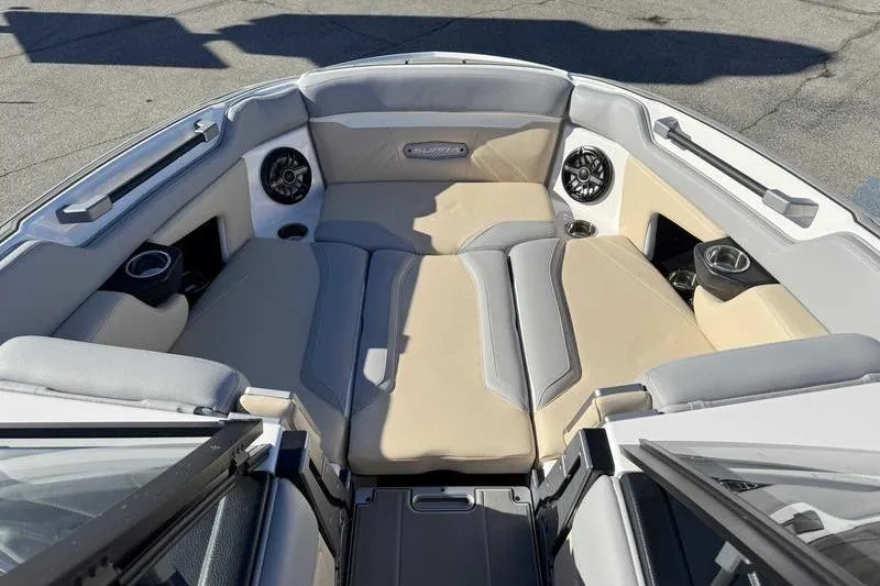 Slide: The Image of 2022 Supra SL boat interior with beige and gray seating, cup holders, and speakers. - 16