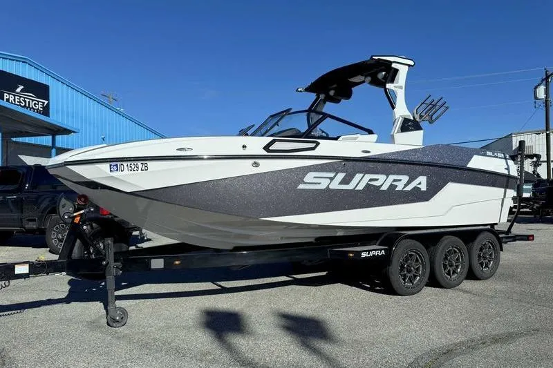 Slide: The Image of 2022 Supra SL boat on trailer at dealership, side view. - 3